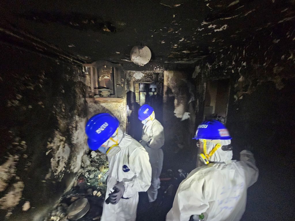 警消手持鏟子進入大樓內部進行開挖,在灰燼中找尋失聯者遺骸。(翻攝FB/香港警察Hong Kong Police)