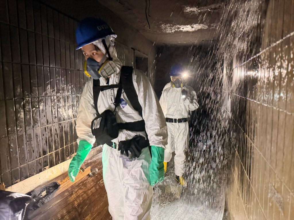 警消手持鏟子進入大樓內部進行開挖,在灰燼中找尋失聯者遺骸。(翻攝FB/香港警察Hong Kong Police)