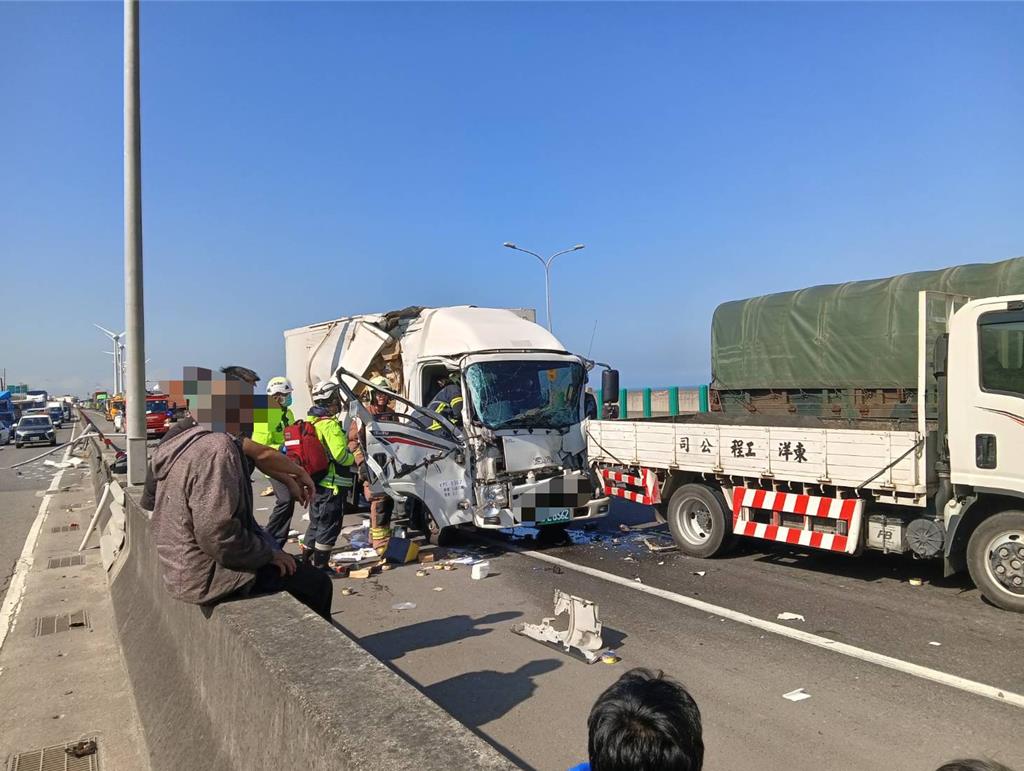 2025年12月16日新北市／61線西濱快速道路往八里方向16日小貨車呂姓駕駛疑似恍神未注意到前方路口的紅燈，煞車不及連環追撞前方2輛大貨車，小貨車嚴重毀損駕駛遭夾車內，警消人員緊急出動協助脫困送醫。（林口警分局提供／吳嘉億新北傳真）