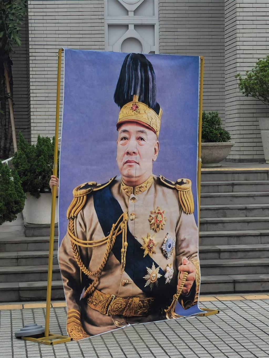 現場擺出賴清德著袁世凱戎裝的合成照，諷刺賴清德稱帝。(黃敬文攝)