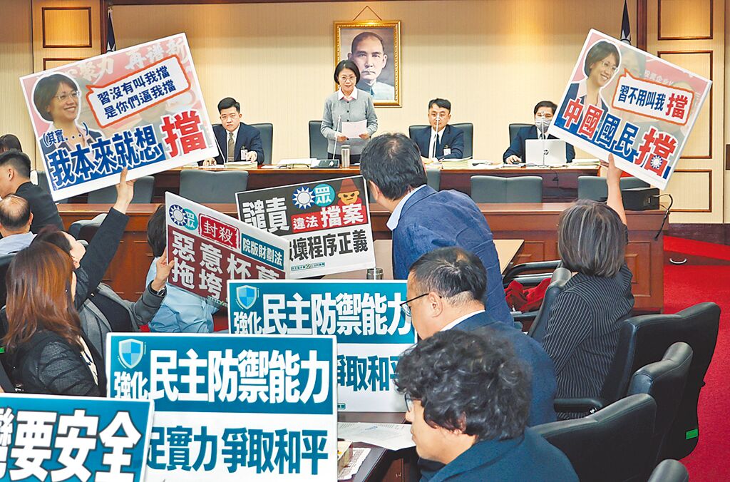 在立法院23日程序委員會中，民進黨立委舉標語抗議藍白及召委翁曉玲（中上）擋國防特別預算條例排入議程。（姚志平攝）