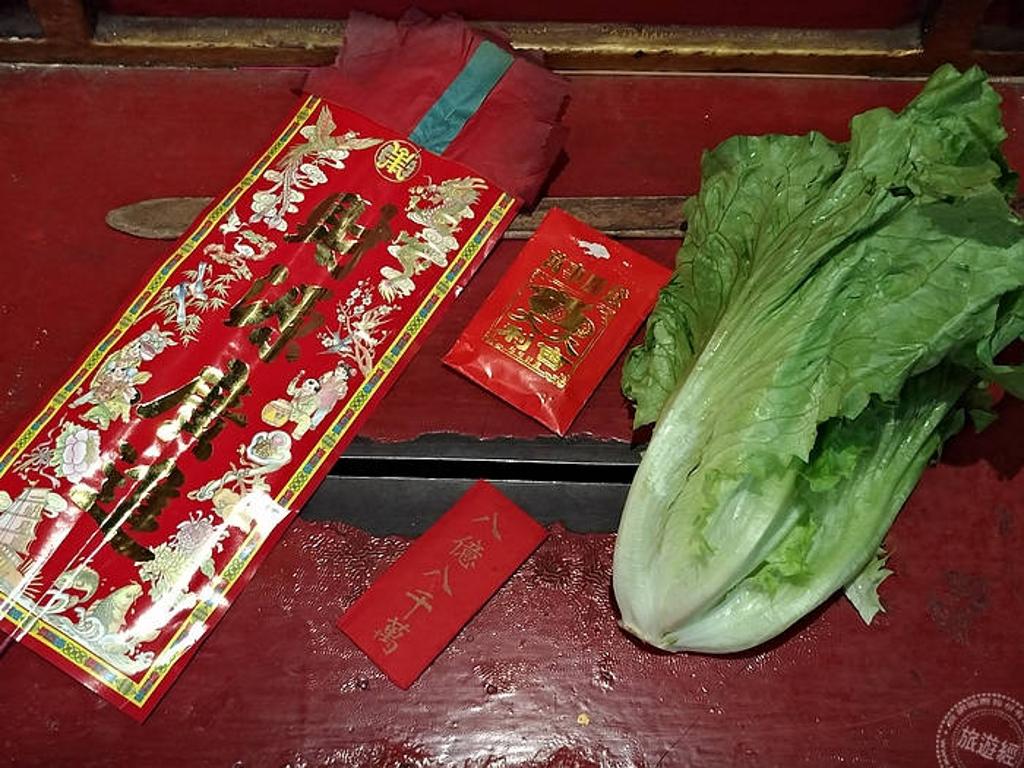 借庫時,廟方會給一棵生菜(生財)、花影、八寶包及庫銀(攝影:洪書瑱)