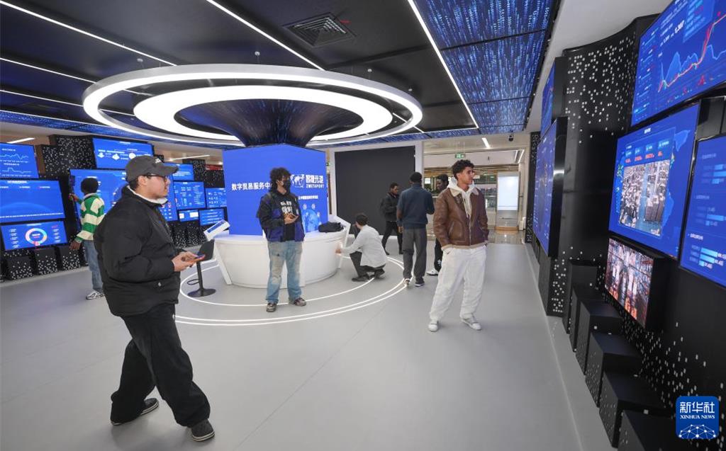 世界超市义乌新春焕新开市。 图为中外客商在义乌全球数贸中心观看数位屏幕。 (新华社)